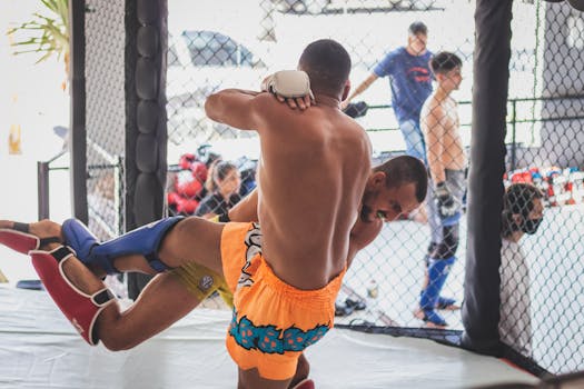 Intense MMA fighters in action during a sparring session inside a training cage.