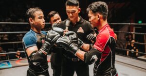 Two boxers and a referee engage in an intense pre-fight moment in the boxing ring.